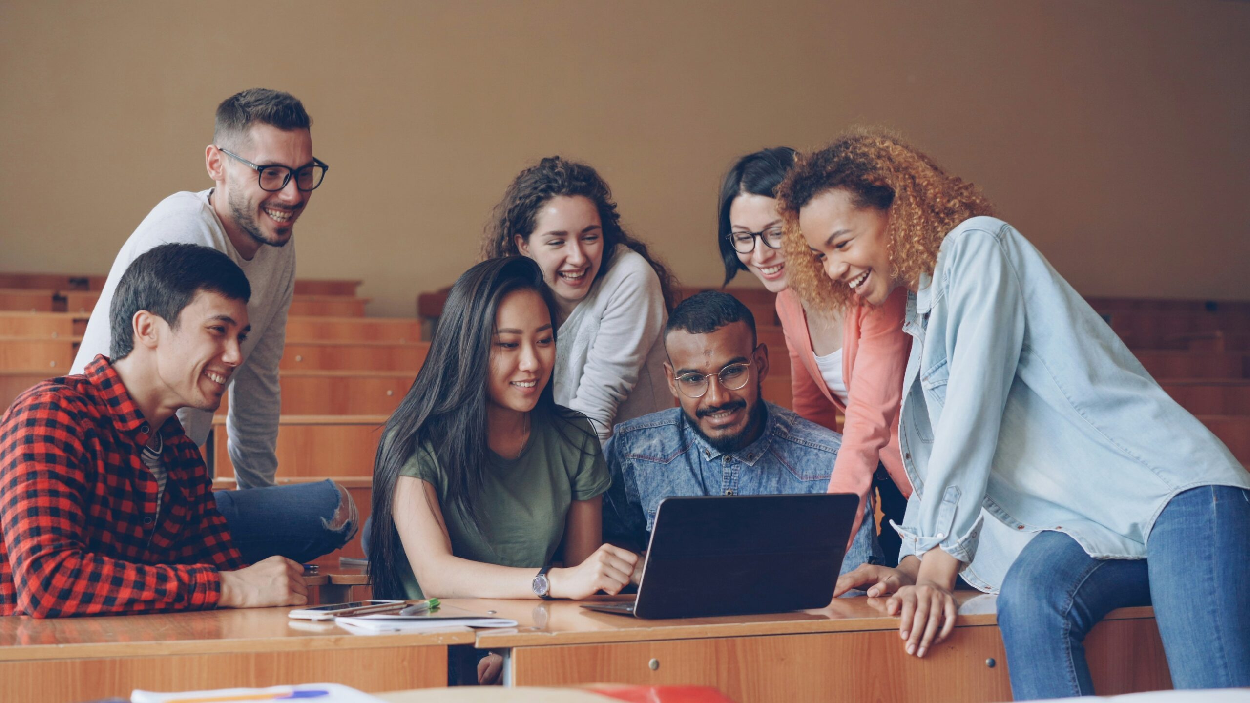 Des étudiants se sont réunis autour d'un ordinateur portable pour réviser ensemble leurs cours.